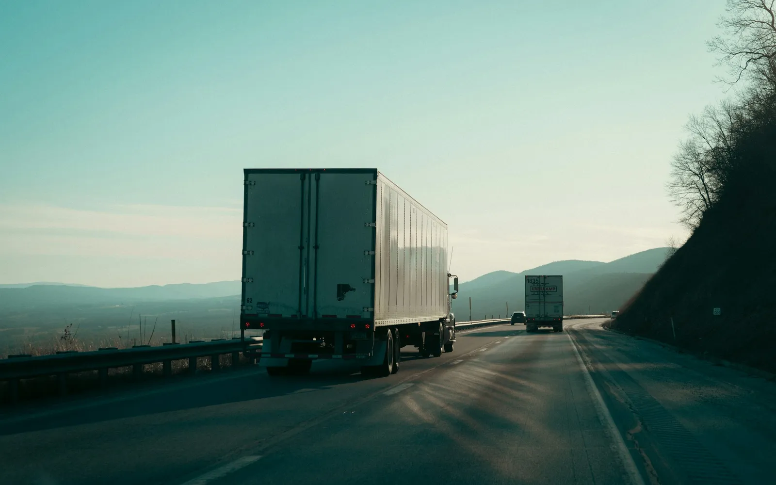 Semi-trucks on a mountain highway at dusk