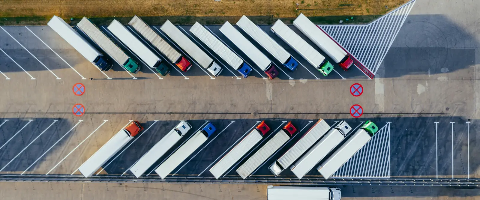 Aerial view of rows of semi-trucks parked in a truck lot